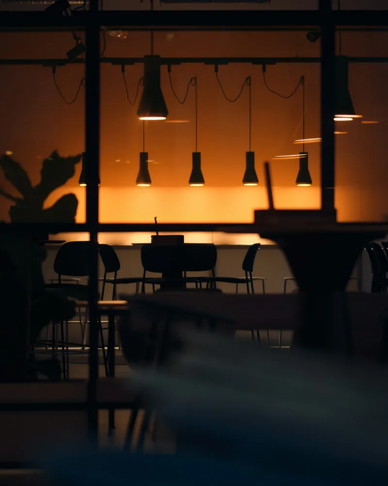 A restaurant lit by pendant lamps at night, sample photo