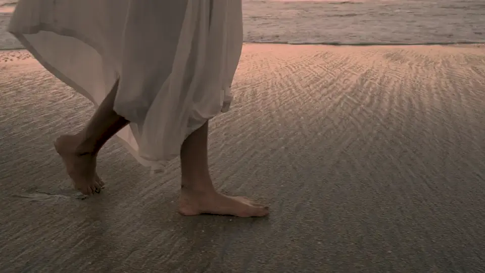 Bare feet walking along the shoreline, still from a sample video