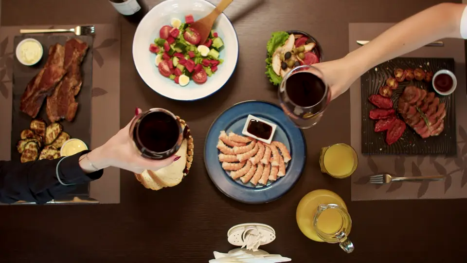 Friends raising glasses over a dinner table, still from a sample video