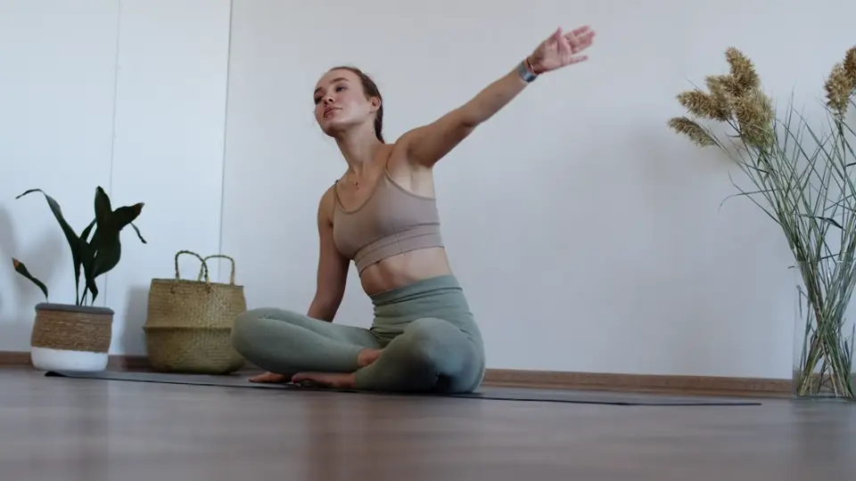 A woman stretching on a mat at home, still from a sample video
